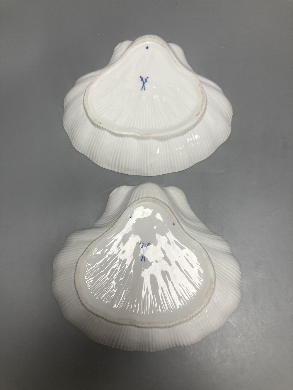 Two Meissen onion pattern shell-shaped dishes, width 19cm, and an English porcelain cabinet cup, inscribed in gilt, Think on me
